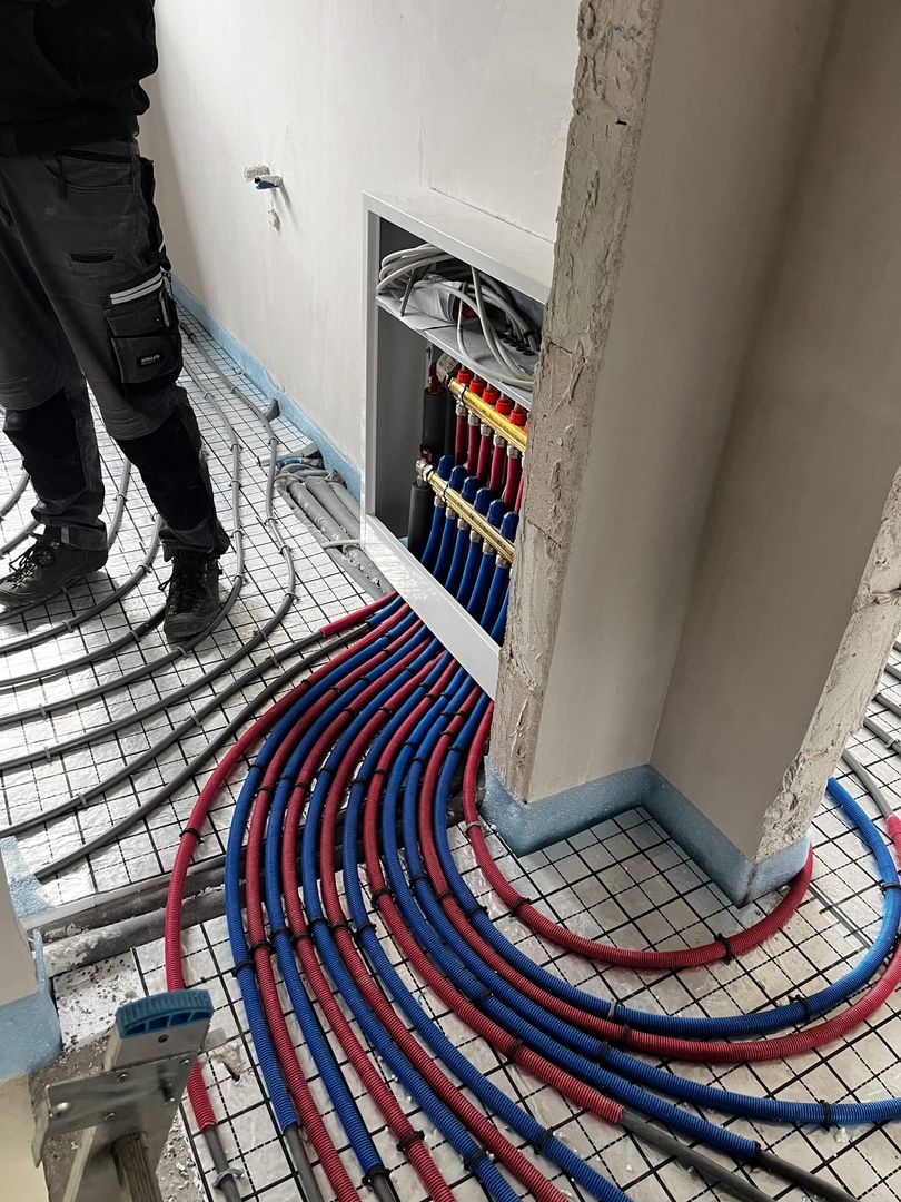 Ein Mann arbeitet auf dem Boden mit blauen und roten Schläuchen